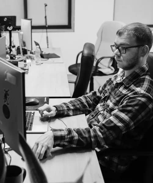 A developer working at a laptop beside a monitor