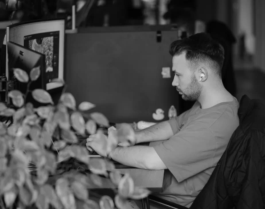 Developer working at a desk behind office plants