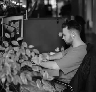 Developer working at a desk behind office plants
